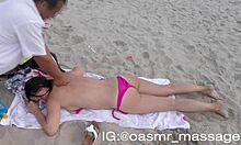 Ung flickvän ger topless massage på stranden
