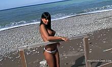 Hlúpa tínedžerská brunetka s obrovskými falošnými prsiami pózuje priamo na pláži