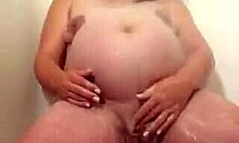 Mama hamil yang besar sedang menggoda dengan masturbasi di bawah pancuran shower