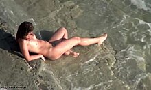 Morena grossa andando em uma praia de nudismo totalmente nua