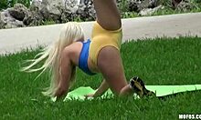 Szőke jóga csaj edz egy nyilvános parkban