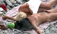 Blondie jerks her boyfriend's cock on a beach