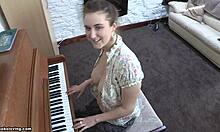 Hravá brunetka s energickými prsiami hrá na klavíri hore bez
