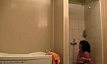 Соблазнительная женщина расслабляется под душем и получает наблюдение