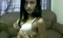 Uma beleza asiática mostrando seu corpo em casa, fazendo um clipe