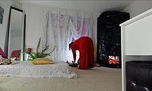 Sensual mature Sonia's home video showcasing her teasing poses in a lengthy red dress, revealing her hairy upskirt, legs, feet, and hips, with natural breasts.