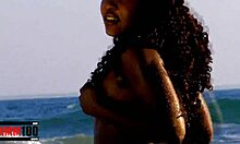Dusná černá žena si užívá svlékání v oceánu