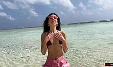 Златен душ на плажа в Малдивите за красива момиче, което пикае