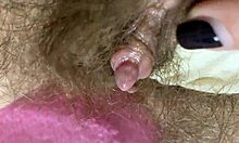 Extrémní detailní záběr velké kundičky klitorisu, která je třena a stříkana